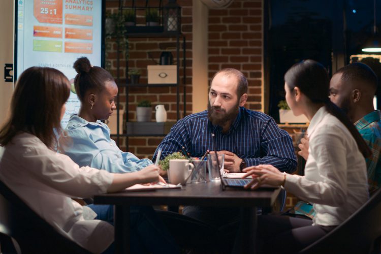 Diverse coworkers brainstorming, team leader explaining strategy plan