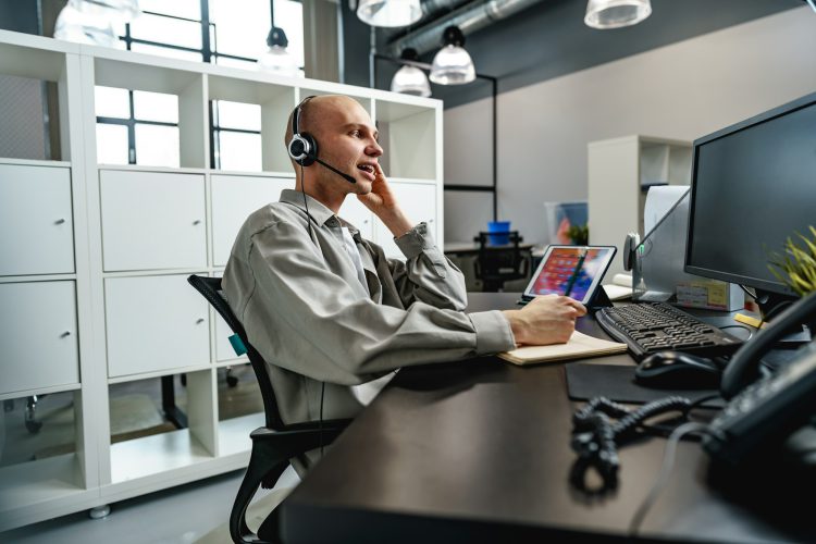 Young bald man working in a call center office